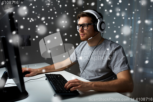 Image of man in headset playing computer video game at home