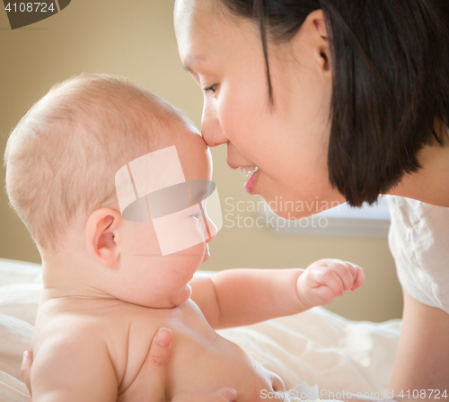 Image of Mixed Race Chinese and Caucasian Baby Boy Laying In Bed with His