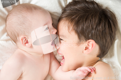 Image of Mixed Race Chinese and Caucasian Baby Brothers Having Fun Laying