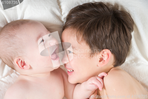 Image of Mixed Race Chinese and Caucasian Baby Brothers Having Fun Laying