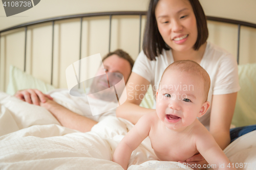 Image of Chinese and Caucasian Baby Boy Laying In Bed with His Parents
