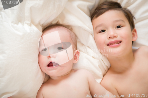 Image of Mixed Race Chinese and Caucasian Baby Brothers Having Fun Laying