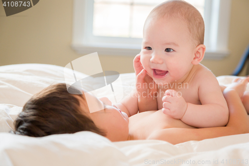 Image of Mixed Race Chinese and Caucasian Baby Brothers Having Fun Laying