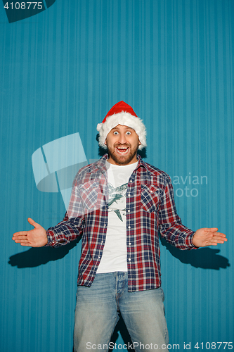 Image of Surprised christmas man wearing a santa hat