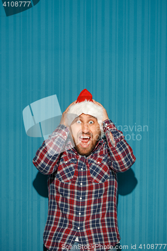 Image of Surprised christmas man wearing a santa hat