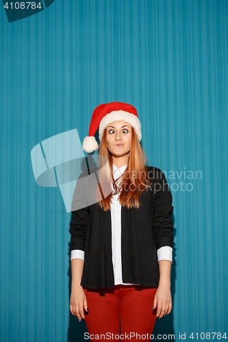 Image of Surprised christmas girl wearing a santa hat