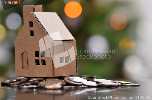 Image of Model of house with coins on wooden table