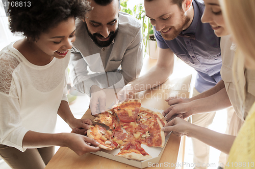 Image of happy business team eating pizza in office