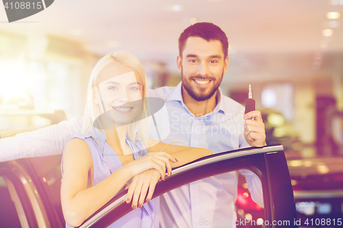 Image of happy couple buying car in auto show or salon