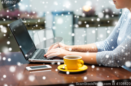 Image of close up of woman typing on laptop with coffee