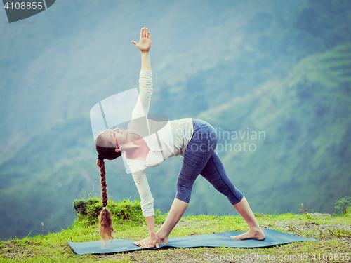 Image of Woman doing Ashtanga Vinyasa yoga asana Parivrtta trikonasana