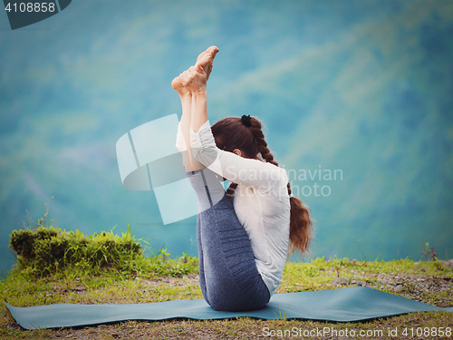 Image of Woman practices yoga asana Urdhva mukha paschimottanasana 