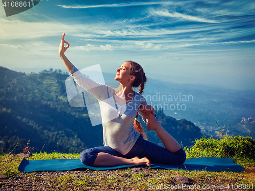 Image of Sorty fit woman doing yoga asana outdoors in mountains