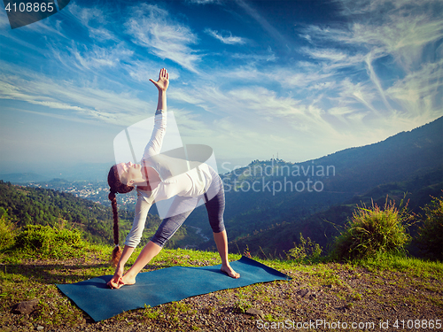 Image of Woman doing Ashtanga Vinyasa yoga asana Utthita trikonasana