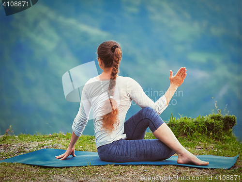 Image of Woman practices yoga asana outdoors