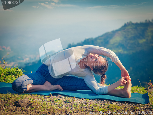 Image of Young sporty fit woman doing Hatha Yoga asana