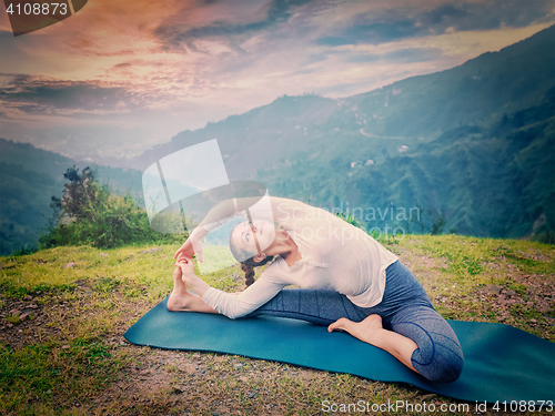 Image of Young sporty fit woman doing Hatha Yoga asana