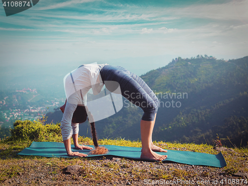 Image of Woman doing Ashtanga Vinyasa Yoga asana Urdhva Dhanurasana