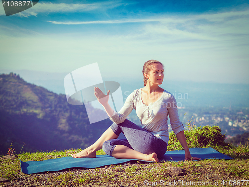 Image of Woman doing Ardha matsyendrasana asana outdoors