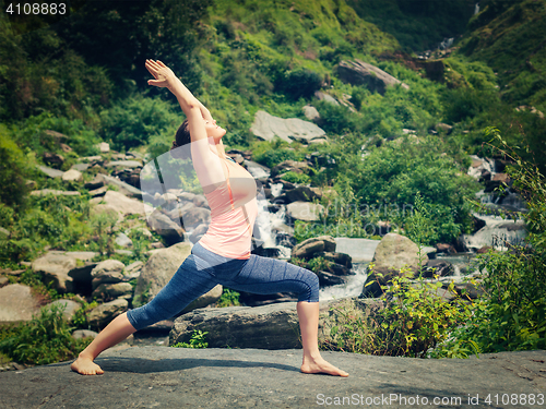 Image of Woman doing Ashtanga Vinyasa Yoga asana Virabhadrasana 1 Warrior