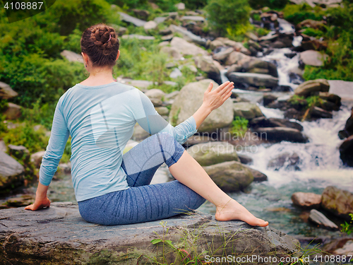 Image of Woman doing Ardha matsyendrasana asana outdoors