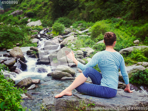 Image of Woman doing Ardha matsyendrasana asana outdoors