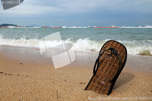 Image of Beach slippers on a sandy beach