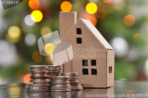 Image of Model of house with coins on wooden table