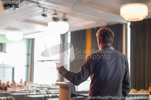 Image of Public speaker giving talk at business event.