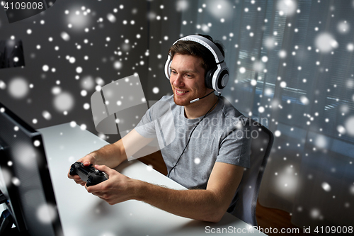 Image of man in headset playing computer video game at home