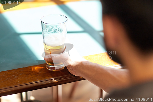 Image of close up of man drinking beer at bar or pub