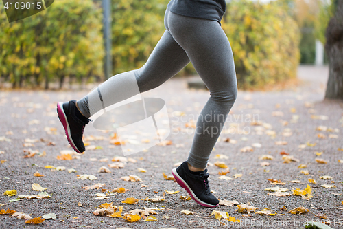 Image of close up of young woman running in autumn park