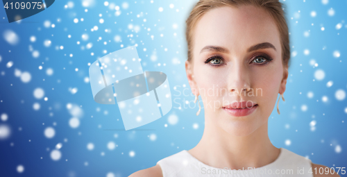 Image of face of beautiful woman in white over snow