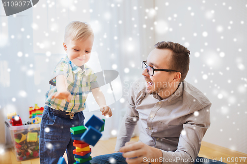 Image of father and son playing with toy blocks at home