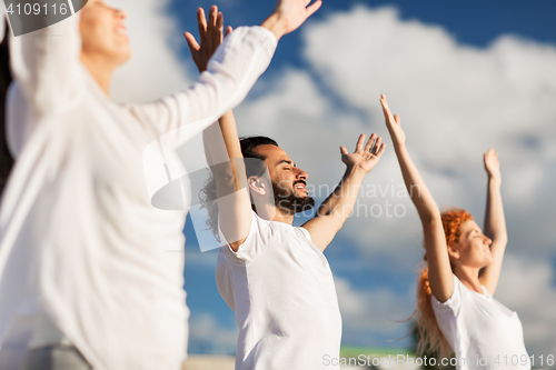 Image of group of people making yoga exercises outdoors