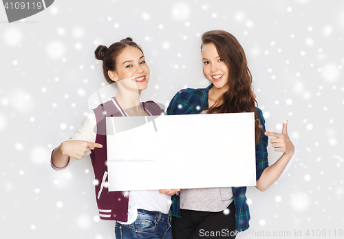 Image of smiling teenage girls holding white blank board