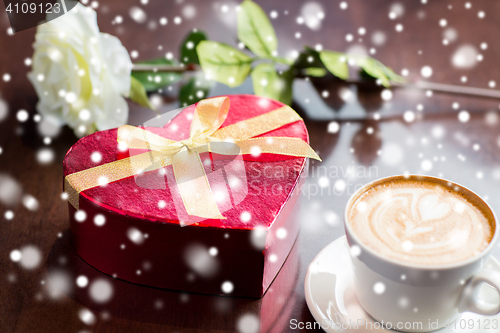 Image of close up of gift box and coffee cup on table