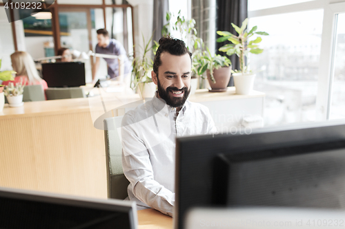 Image of happy creative male office worker with computer