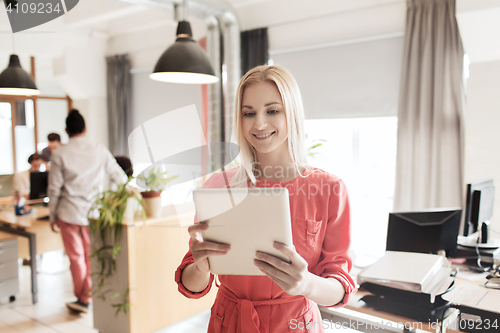 Image of happy creative female office worker with tablet pc