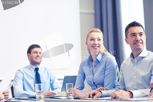 Image of group of smiling businesspeople meeting in office