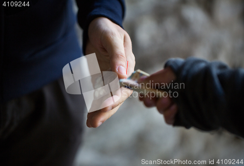 Image of close up of addict buying dose from drug dealer