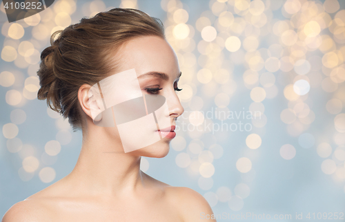 Image of beautiful young woman face over lights background