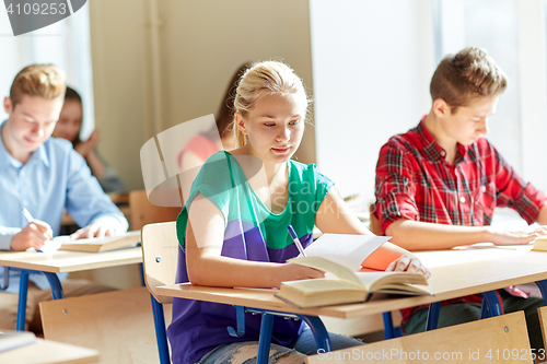 Image of group of students with books writing school test