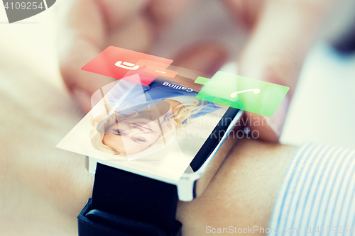 Image of close up of hand with incoming call on smart watch