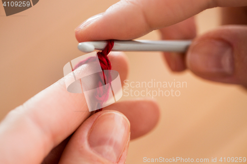 Image of close up of hands knitting with crochet hook