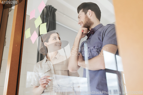 Image of happy creative team talking at office