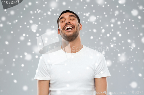 Image of happy laughing man over snow background