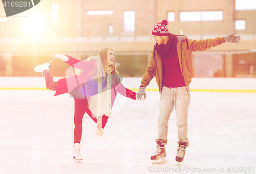 Image of happy couple holding hands on skating rink