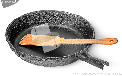 Image of Old cast iron pan with wooden spatula