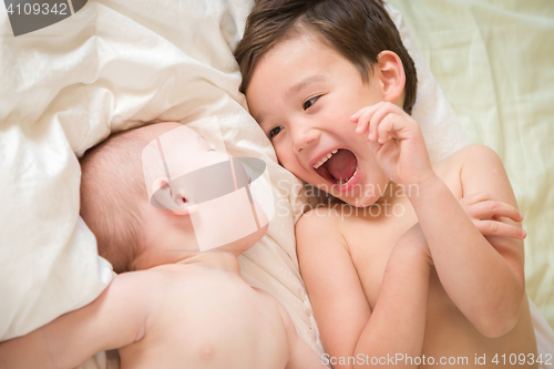 Image of Mixed Race Chinese and Caucasian Baby Brothers Having Fun Laying